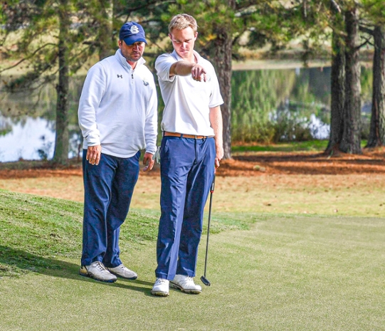 “Cleveland State Community College nationally-ranked golfer Wes Spillers, right, and Cleveland State Community College Golf Head Coach Miles Moseley read a green at the Eagle Invitational at Nob North Golf Course in Dalton, Georgia in October 2019.”